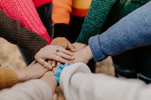 lots of hands on top of each other in a circle