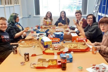 Senedd members eating pizza