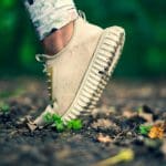 White running shoe on muddy ground